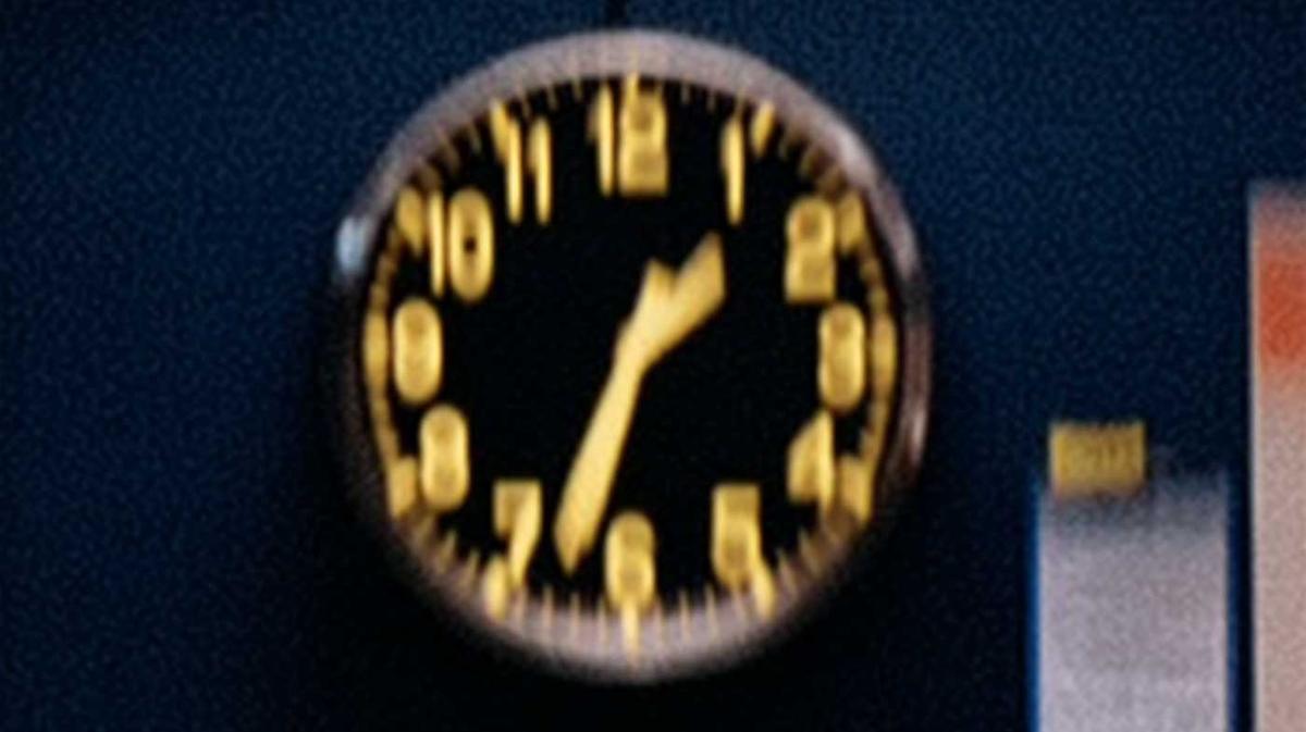 A close view of a clock with yellow numbers