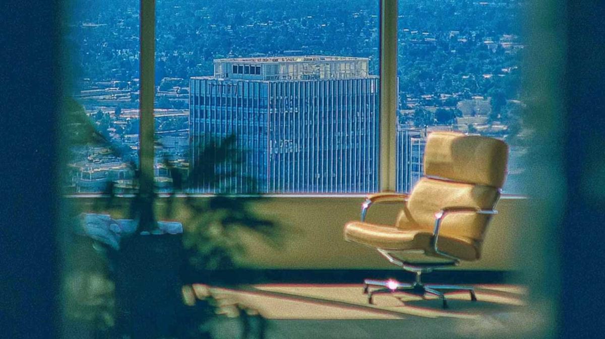 An uncluttered chair beside a large office window